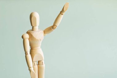 Ahşap bir manken selamlama, elveda ya da oy vermek için elini kaldırdı. Bir yazı için boş yer. Yakın plan.