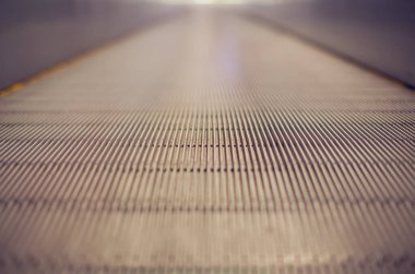 Alışveriş merkezinde merdivensiz yürüyen merdiven. Merdivenlerden iniyorum. Metal platformu kapatın. Üst görünüm.