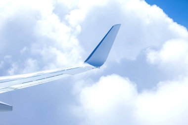 Hava sahasının kanatları mavi gökyüzüyle bulutların üzerinde uçuyor..