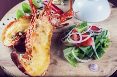 Bir sürü sebzeyle süslenmiş ve kızartılmış lüks bir ıstakoz tabağı.