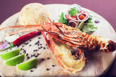 Bir sürü sebzeyle süslenmiş ve kızartılmış lüks bir ıstakoz tabağı.