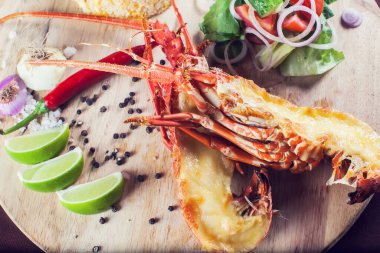 Bir sürü sebzeyle süslenmiş ve kızartılmış lüks bir ıstakoz tabağı.