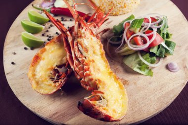 Bir sürü sebzeyle süslenmiş ve kızartılmış lüks bir ıstakoz tabağı.