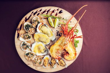 Bir sürü sebzeyle süslenmiş ve kızartılmış lüks bir ıstakoz tabağı.