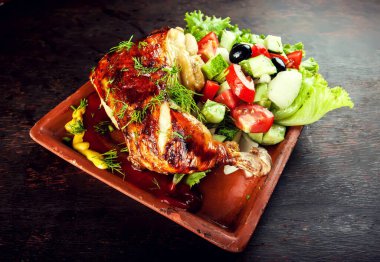 Zeytin yağı ve salatayla kızartılmış tavuk budu.