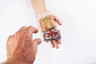 Fare kapanında eli olan bir para. Beyaz bir arkaplanda.