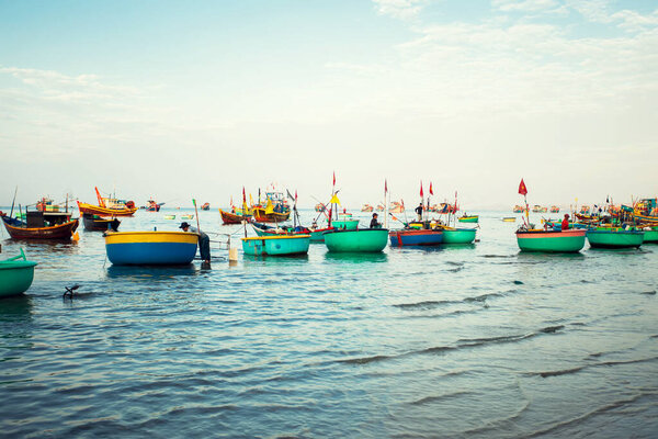 Traditional old wooden Vietnamese boats and round fishing boats in the sea