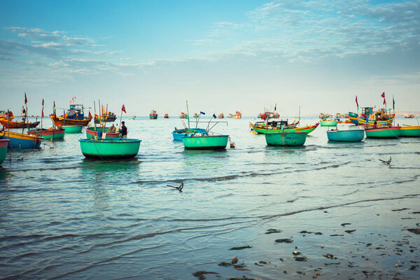 Traditional old wooden Vietnamese boats and round fishing boats in the sea