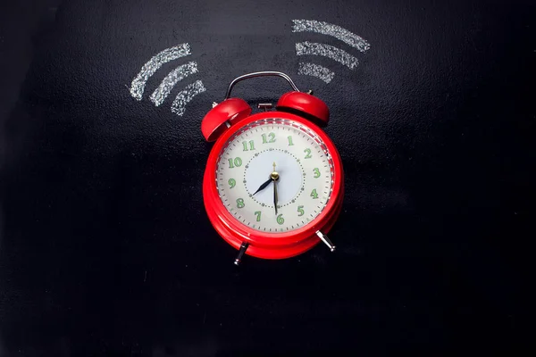 Alarm clock ringing on the dark surface. Morning or time management concept