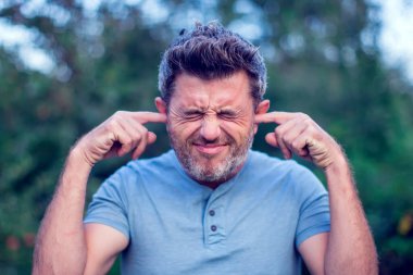 Delikanlının portresi ellerini kulaklarının üzerinde tutuyor açık havada duymamak için.