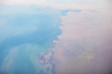 Uçus sirasinda uçak penceresinden zemine bakin. Yeryüzü üzerindeki manzara çok güzel..