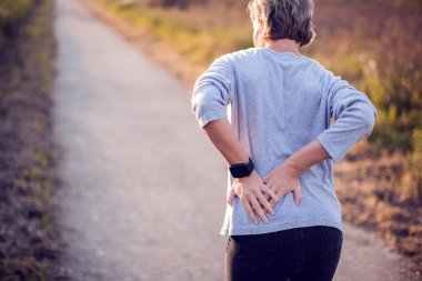 İnsanlar, sağlık ve sorun konsepti - kadın arka tarafta ya da dışarıda acıdan muzdarip