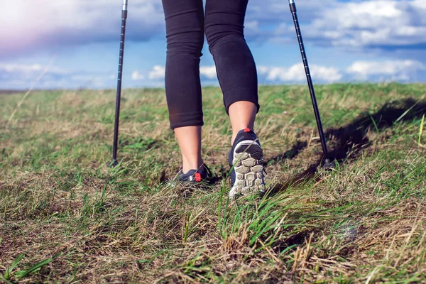 Nordic walking, exercise, sport, adventure, hiking concept -a woman hiking in the nature