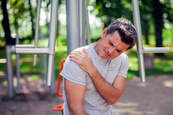 在公园里的运动和锻炼中 不快乐的男人感到肩膀疼痛 医学和人的概念 — 图库照片