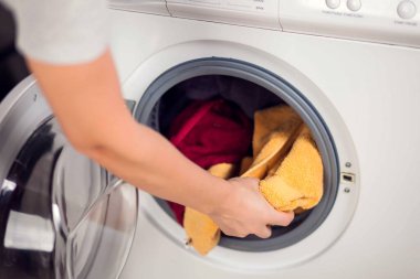 Çamaşır makinesine çamaşır yüklemek. Ev işi, çamaşır konsepti.