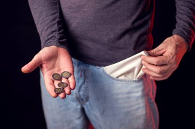 Adamın elinde kotunun ve sikkelerinin boş cebi var. Yoksulluk, mali sorunlar kavramı