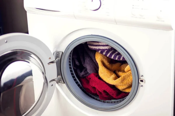 Loading clothes in washing machine. Housework, laundry concept