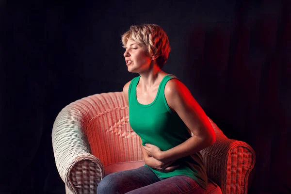 黒い背景の前で強い胃や月経痛を感じる女性 健康管理と身体的概念 — ストック写真