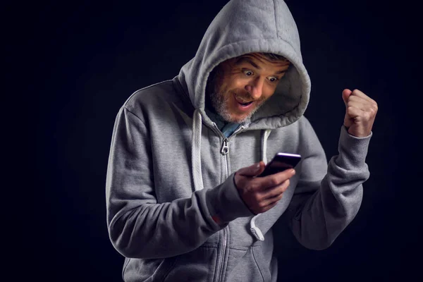 Man Hooded Sweater Holds Phone Hands Feels Happy People Gadget — Stock Photo, Image