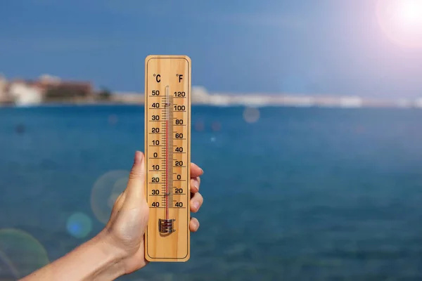 Hand Van Vrouw Houdt Thermometer Strand Achtergrond Zomer Klimaat Weerconcept — Stockfoto
