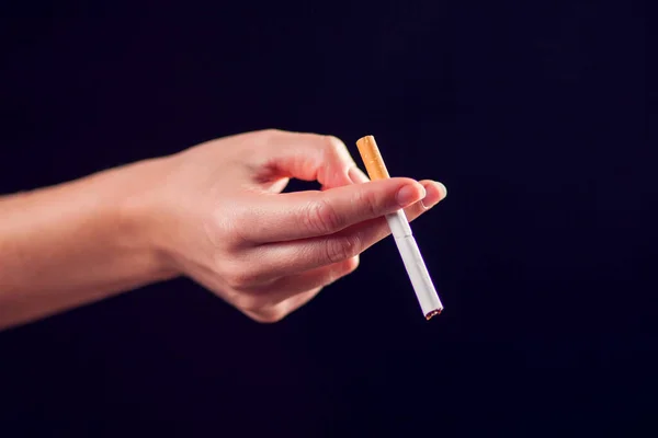 黒の背景に手にタバコ 煙中毒の概念 — ストック写真