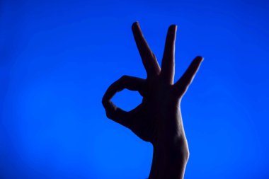 Tamam, mavi arkaplan önünde siyah sembol.