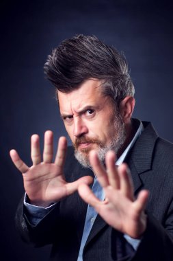 Ciddi sakallı bir adamın portresi. Iroquois takım elbiseli, dur işareti yapıyor. İnsanlar ve duygular