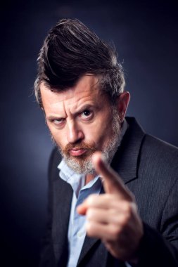 Iroquois takım elbiseli komik sakallı bir adamın fotoğrafı. Kameraya parmağını gösteriyor. İnsanlar ve duygular