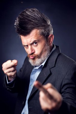 Kameraya orta parmağını gösteren iroquois takım elbiseli saldırgan sakallı bir adamın portresi. İnsanlar ve duygular