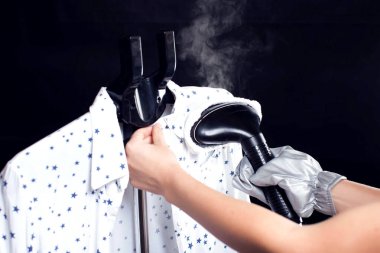 Siyah arka planda buharlı bluz giyen kadın. Hausework, yaşam tarzı konsepti