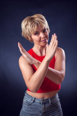 Kırmızı tişörtlü, kısa sarı saçlı genç bir kadının portresi dur ya da siyah arkaplan önünde yüz ifadesi yok. Yaşam tarzı ve kötü duygular kavramı