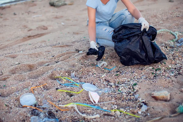 장갑을 물건을 셔츠를 여자가 해변에서 쓰레기를 수거하고 — 스톡 사진