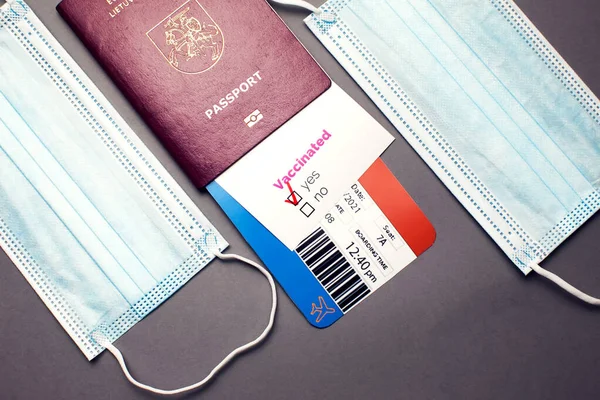 Traveling during COVID-19 pandemic, passport with airline ticket, covid-19 vaccinated card with \