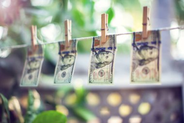 Para aklamak için ipte asılı duran Amerikan doları banknotları