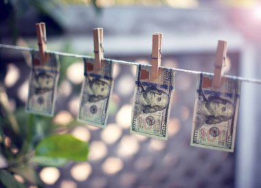 Para aklamak için ipte asılı duran Amerikan doları banknotları