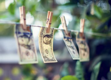 Para aklamak için ipte asılı duran Amerikan doları banknotları