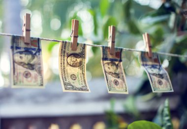Para aklamak için ipte asılı duran Amerikan doları banknotları