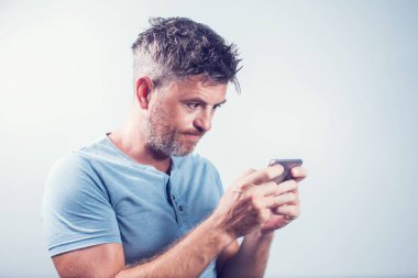 Cep telefonu kullanan yakışıklı genç adam izole edilmiş.