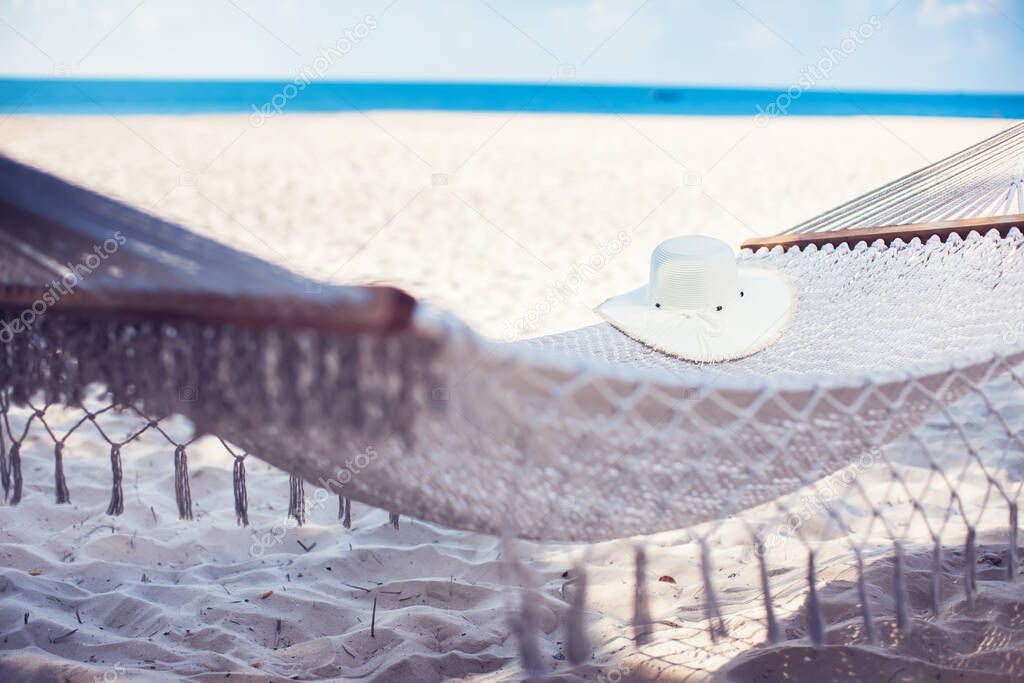 White hat on hammock at the tropical sand beach for summer background