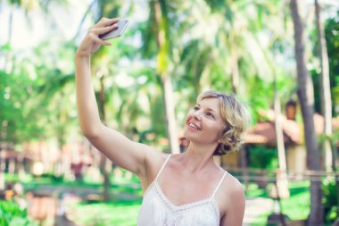 Açık havada cep telefonu kullanan güzel bir kadının portresi.