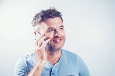 Cep telefonu kullanan yakışıklı genç adam izole edilmiş.