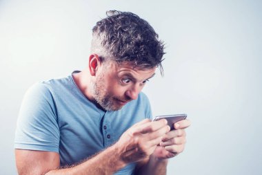 Cep telefonu kullanan yakışıklı genç adam izole edilmiş.