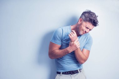 İnsanlar, sağlık ve sorun konsepti - gri arka planda acı çeken mutsuz bir adam