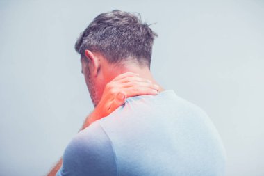 İnsanlar, sağlık ve sorun konsepti - Gri arka planda boyun ağrısından muzdarip adama yakın çekim