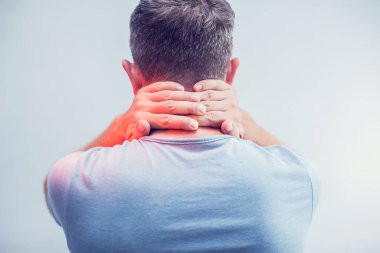 İnsanlar, sağlık ve sorun konsepti - Gri arka planda boyun ağrısından muzdarip adama yakın çekim