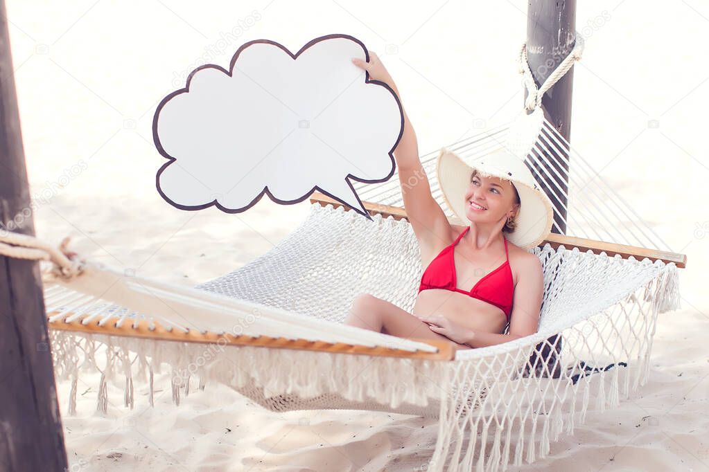 Cloud storage, travel, summer concept. Woman in bikini holding paper cloud icon on the hammock.