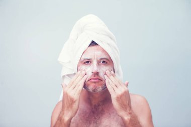 Yüzünde nemlendirici olan genç bir adam.