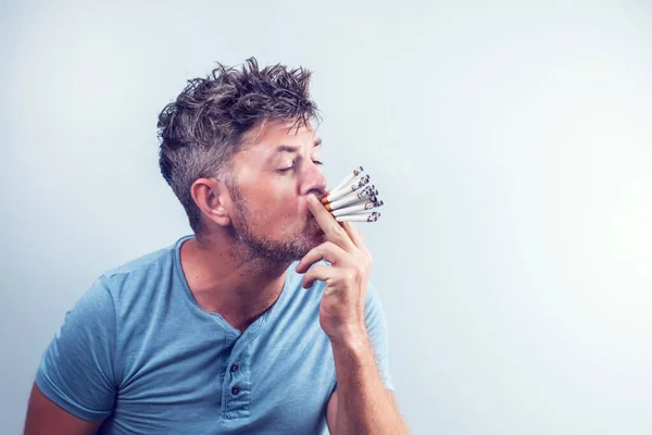 Jeune Homme Avec Beaucoup Cigarettes Dans Bouche Image En Vente