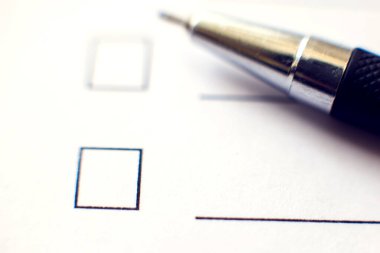 Beyaz kağıda kalem iliştirilmiş kontrol listesi. İşaretleme kutusu konsepti.