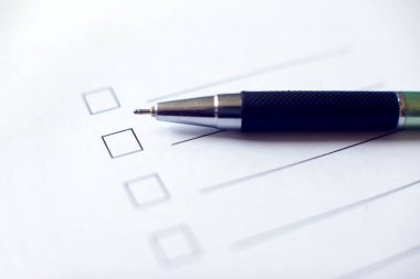 Beyaz kağıda kalem iliştirilmiş kontrol listesi. İşaretleme kutusu konsepti.